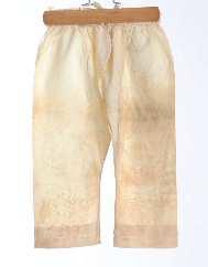 UF 67-43-57 pantalon 1840 (vers) Pantalon d'enfant ; en linon blanc ; entièrement ouvert à l'entrejambe; à jambes longues et étroites, garni de deux volants au bas de la jambe ; terminées par une