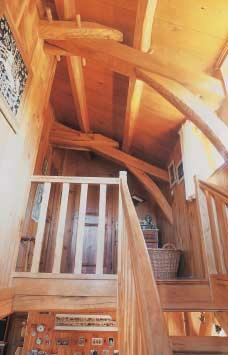Cet escalier se distingue également par la combinaison de marches et de mains courantes en bois naturel huilé avec des contremarches, limons, poteaux et balustres peints en blanc.