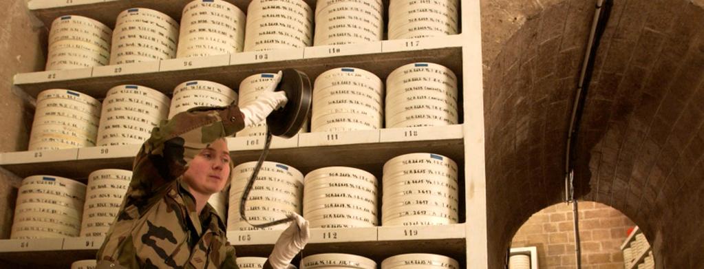 Cliché gauche : 54/ Référence : D127-20 Le soldat Jean-Hugo Hoarau retire une boîte contenant des plaques de verre de la Première Guerre mondiale conservée dans un magasin du pôle des archives.