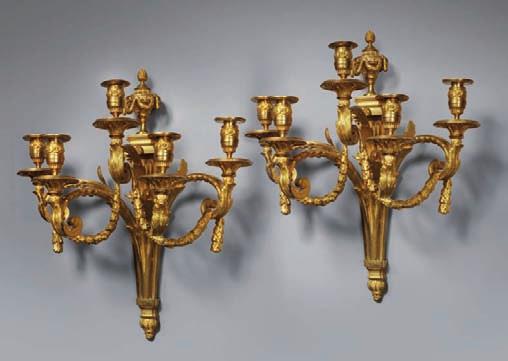 613 613 Série de quatre appliques en bronze ciselé et doré à deux bras de lumière formés d un enroulement souligné d une agrafe d acanthe et surmonté d une tête de bélier.