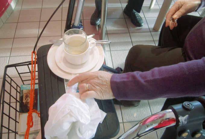 Pratiques en EMS De nombreux résidents aident à débarrasser la table, déposent la vaisselle sur la tablette de leur rollator puis sur le chariot.