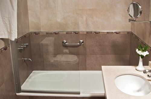 MEUBLES 4- Salle de bains avec surfaces antidérapantes et pellicule de protection sur tous les éléments de verre et de miroirs pour prévenir les accidents.