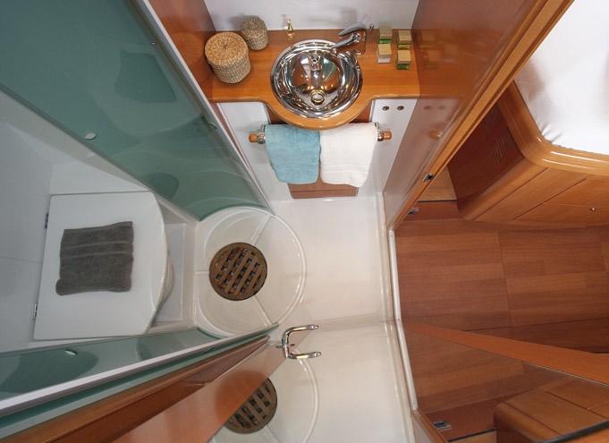 At the head of the bed on the aft starboard side, there is a large opening hatch sheltered by a long awning that provides an excellent view aft and both light and air, even in strong rains.
