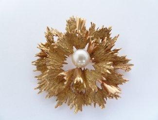 53 Broche Estimation : 200 / 300 Euros Adjugé(e) : 280 Euros Broche fleur en or (perle de culture), travail des années 1970. 12, 8 g brut.