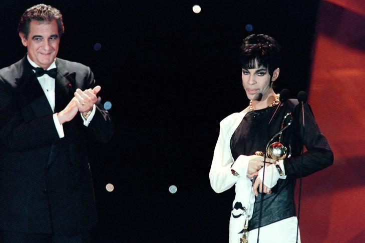 Le chanteur Prince (d) applaudi par le ténor espagnol Placido Domingo (g) après avoir reçu une récompense pour sa contribution à la pop music le 4 mai 1994 à Monaco / AFP/Archives Comme lui, de