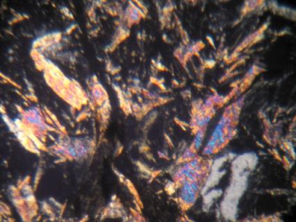 des lamelles de talc et/ou phengite (>95% ; taille de 50 microns à, teintes de polarisation jaune orangé, indigo