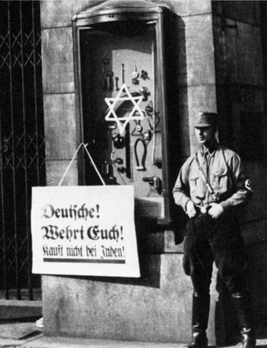 LE BOYCOTT DE MAGASINS JUIFS Un S.A. à côté d'une affiche proclamant : «Allemands!