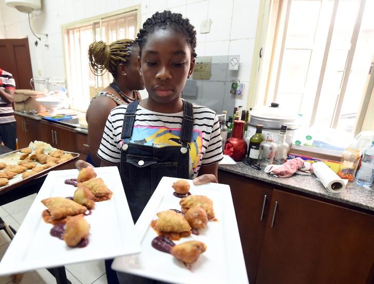 Une jeune Nigériane transporte des plats dans un restaurant de Lagos, le 30 janvier 2016 / AFP Plusieurs jeunes chefs, souvent inspirés par des séjours à l'étranger, commencent eux aussi à se lancer