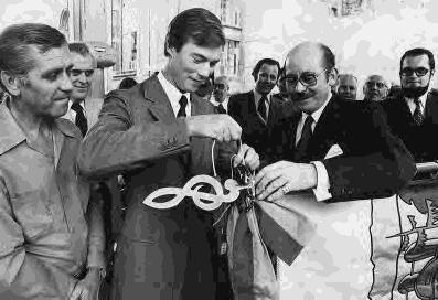 4 juillet 1976. S.A.R. le Grand-Duc héritier Henri attache au nouveau drapeau l écharpe commémorative offerte par la Maison grand-ducale. L après-midi cortège à travers les rues du fau bourg.
