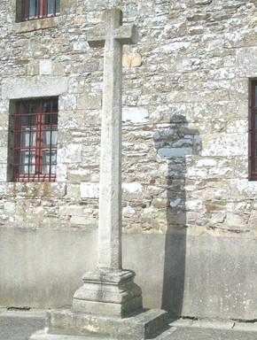 Adossée au transept sud de l église, la longue croix de l ancien cimetière se confond presque avec le mur de l édifice.